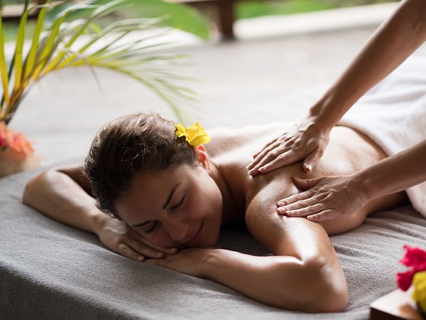 Smiling woman enjoying in a back massage at the spa.